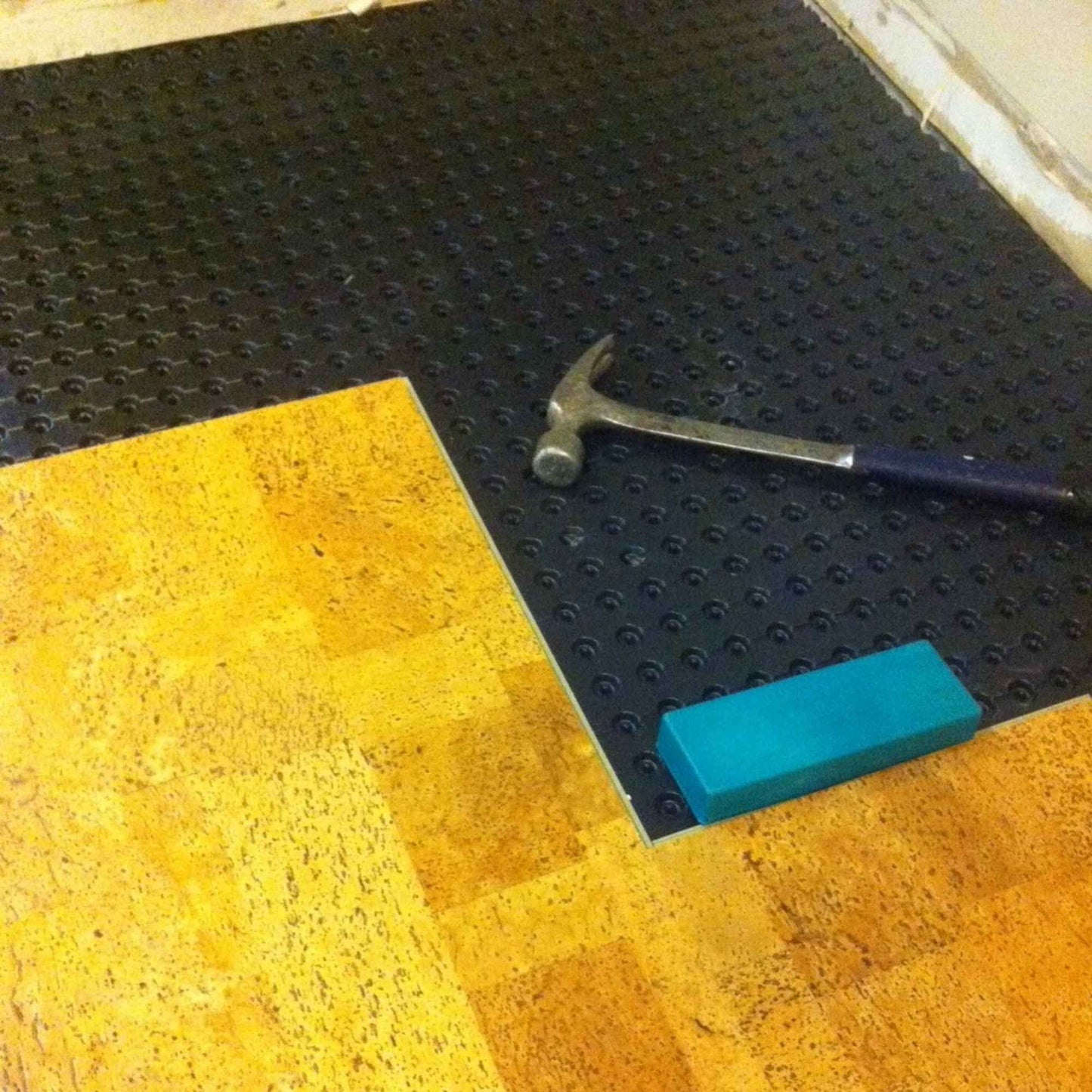 Platon moisture barrier being installed under cork flooring