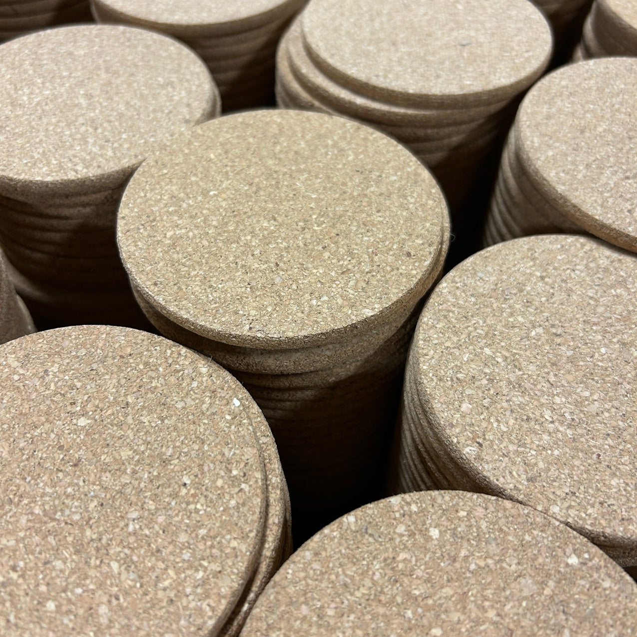 several stacks of round, cork coasters