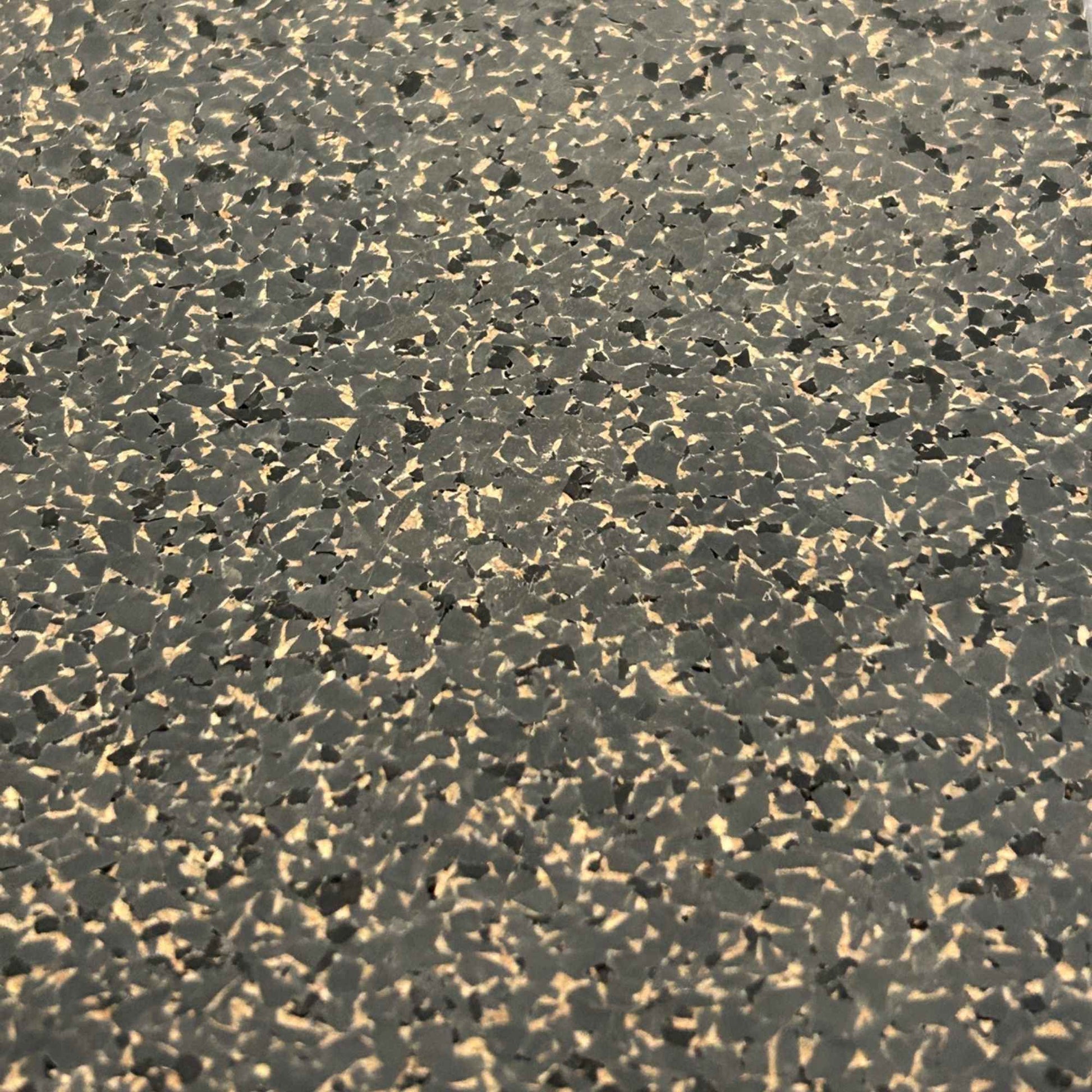 A close-up to show the pattern and colors of the Boulder rubber cork floor tile - speckles of dark grey, tan and black.