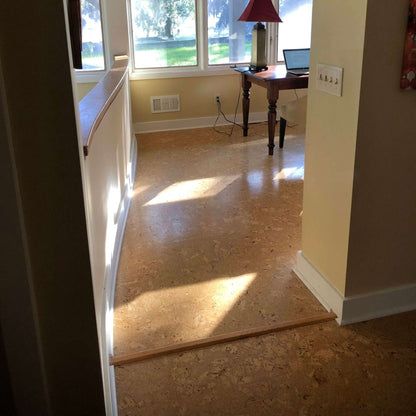 Sierra pattern cork floating floor installed in a home office with a wood transition strip between rooms