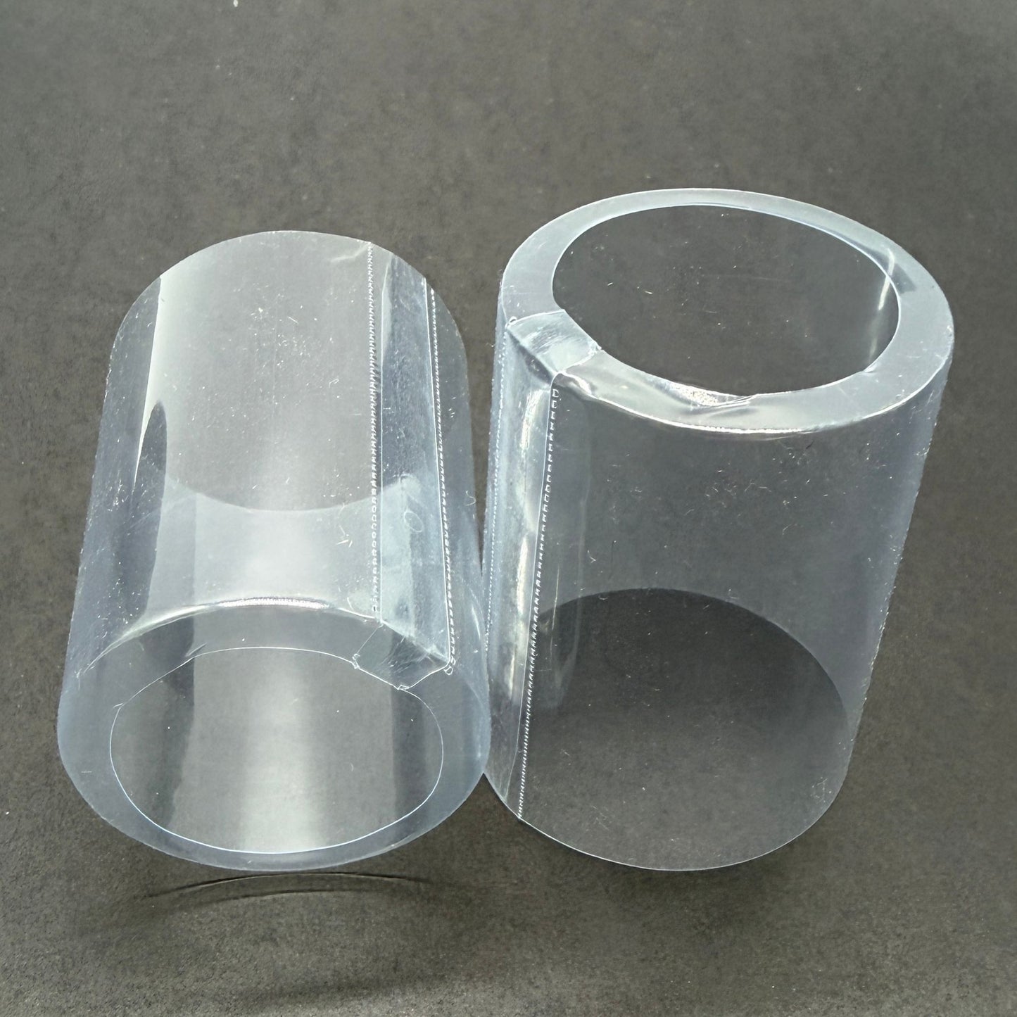 Close-up of two transparent shrink caps with an open cap.